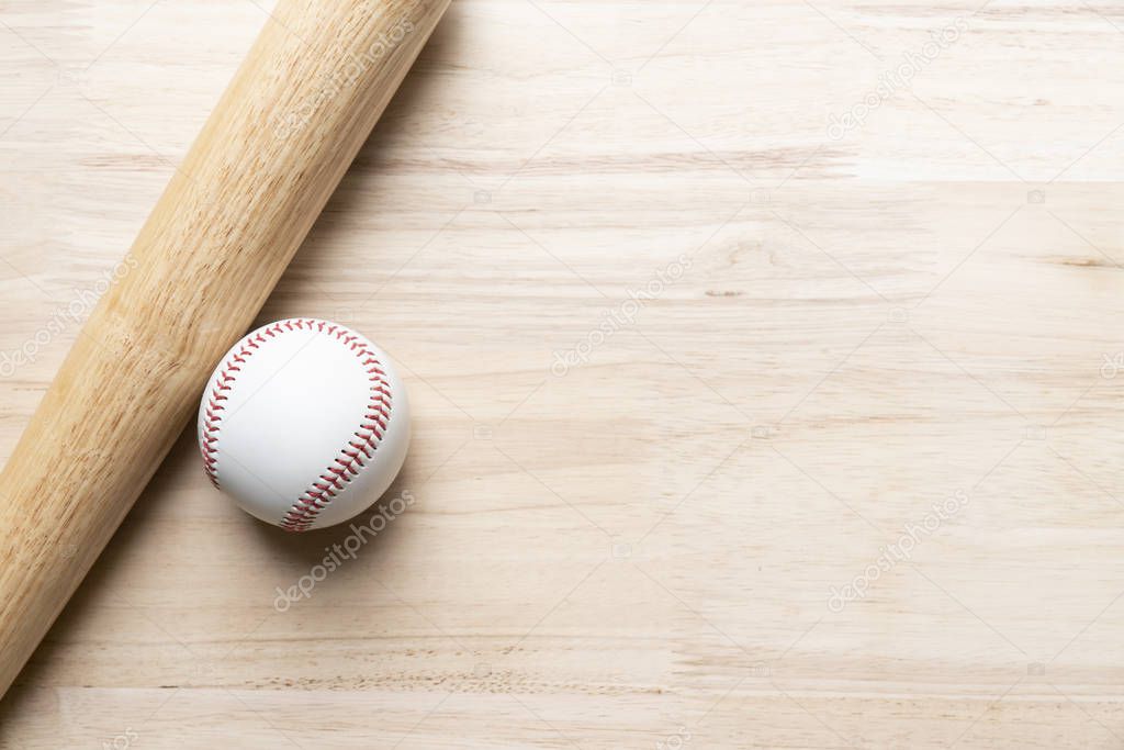 baseball and baseball bat on wooden table background, close up