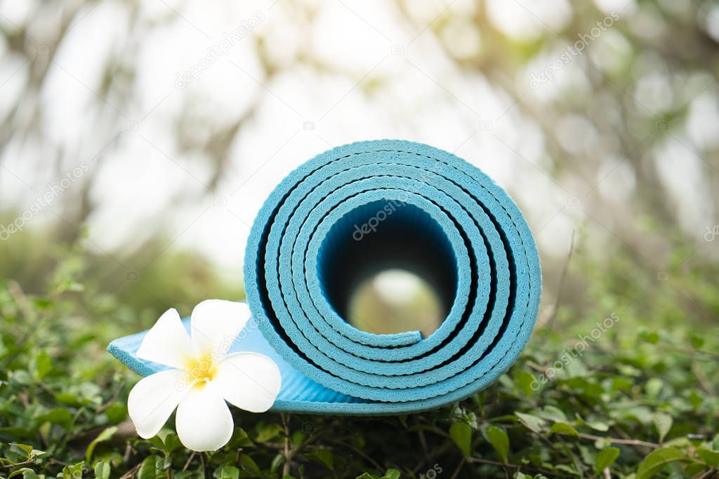 blue yoga mat and a flower outdoor, healthy and sport concept