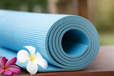 mavi yoga minderi ve çiçek açık, sağlıklı ve spor kavramı