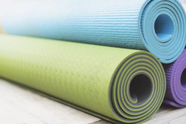 Masadaki renkli yoga minderini, spor ve sağlıklı konsepti kapat.