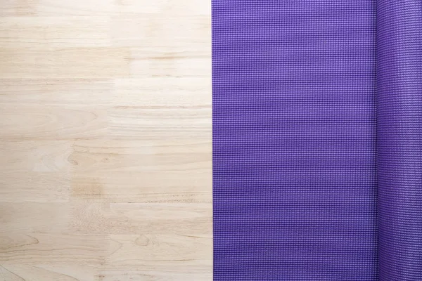 close up of purple yoga mat on the table, sport and healthy concept