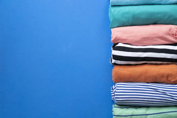 Gros Plan Vêtements Colorés Roulés Sur Fond Bleu — Photo