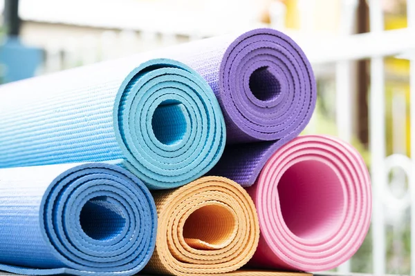 把色彩斑斓的瑜伽垫放在桌上 运动与健康的概念 — 图库照片