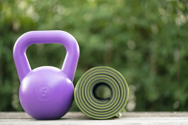 Kettlebell and yoga mat on table, fitness healthy and sport concept