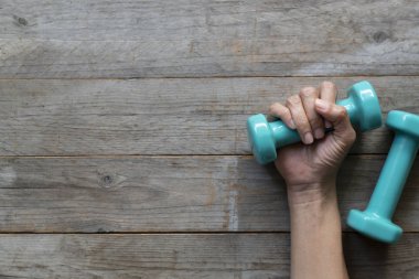 kadın el ahşap masal zemin üzerine yeşil dumbbell tutarak