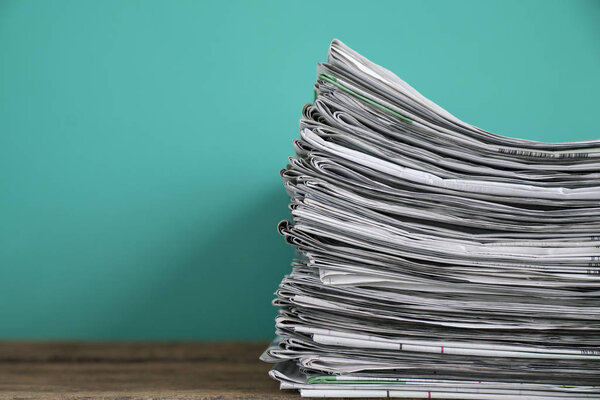 закрыть газеты сложены и сложены на столе с зеленым б
