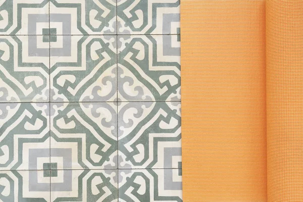 close up of yoga mat on retro floor tile, sport and healthy conc