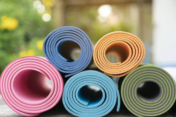 Közelkép a színes jóga matracot a tábla, a sport és az egészséges co — Stock Fotó