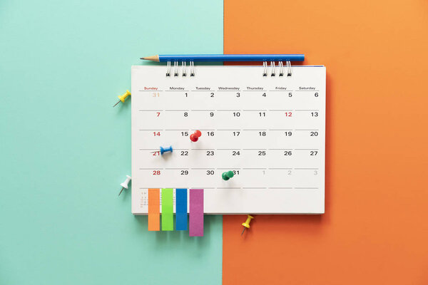 Закрытие календаря на столе с цветовым фоном, планирование
