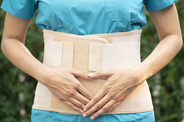 Jovem asiático mulher vestindo volta apoio para proteger ela de volta, med — Fotografia de Stock