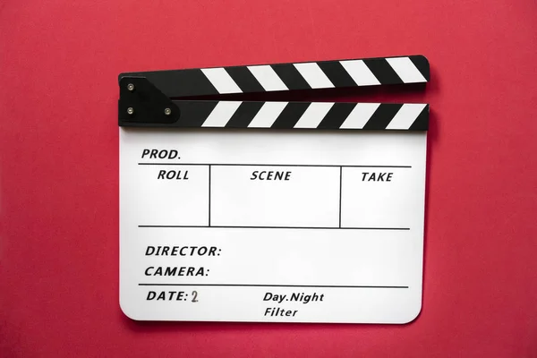 Φιλμ κλπερ σε κόκκινο φόντο τραπέζι? φιλμ, κινηματογράφος και βίντεο p — Φωτογραφία Αρχείου
