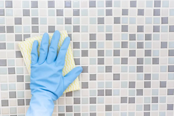 Rengöring kakel vägg av kvinna hand med handske, redo att rengöra hous — Stockfoto