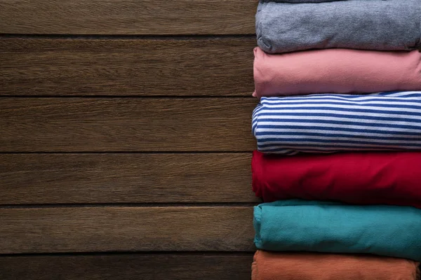 Gros plan de vêtements colorés roulés sur fond de table — Photo