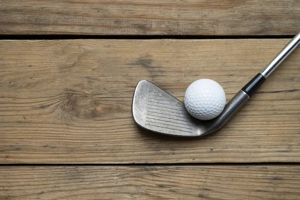 Ahşap masa arka plan üzerinde golf topu ve golf kulübü — Stok fotoğraf