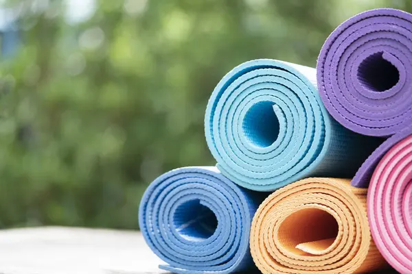 Primer plano de colorido estera de yoga sobre la mesa, deporte y co saludable — Foto de Stock