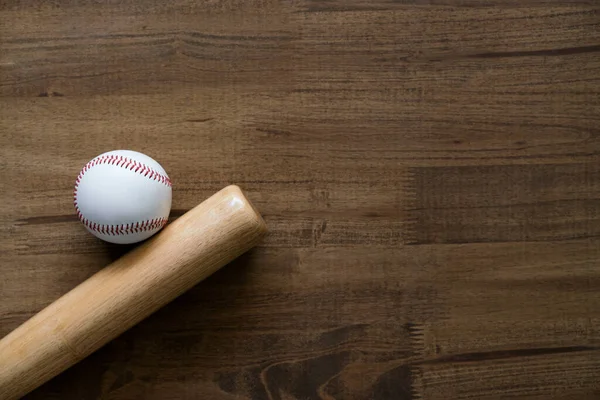 baseball and baseball bat on wooden table background, close up