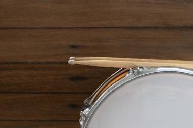 Davul ve davul çubuğu ahşap masa arkasında, üst görünümde, müzik konseptinde