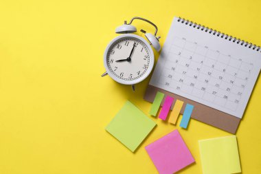 sarı masa arkaplanındaki takvim ve alarmın kapatılması, iş toplantısı ya da seyahat planlama konsepti