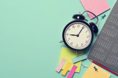 yeşil masa arkaplanındaki alarm saatini ve takvimi kapat, iş toplantısı ya da seyahat planlama konseptini planla