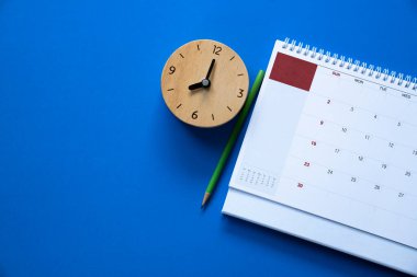 mavi masa arkaplanındaki takvim ve alarmın kapatılması, iş toplantısı ya da seyahat planlama konsepti