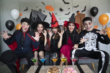 Genç Asyalı insanlar, beş kişilik bir grup, korkunç kostümler içinde. Cadılar Bayramı kıyafetleri giyen bir grup arkadaş bir partiye katılmaya hazırlanıyor.. 