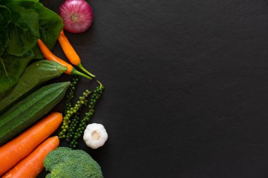 Taze çiftçiler yukarıdan meyve ve sebze pazarlıyorlar. Siyah arka planda fotokopi alanı var. Sağlıklı gıda kavramı.