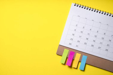 sarı masa arkaplanındaki takvimi kapat, iş toplantısı ya da seyahat planlama konseptini planla