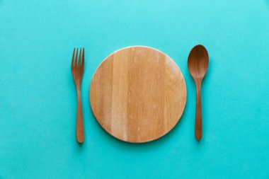Kaşık ve çatal kesme tahtasında yeşil masa arka planı, yiyecek ve sağlıklı konsept