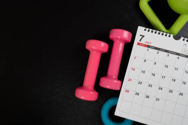 Siyah arka plan, spor ve sağlıklı konsepte sahip takvim ve ekipman sporu zamanı