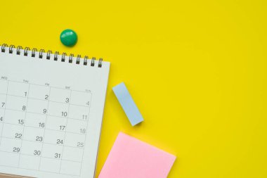 sarı masa arkaplanındaki takvimi kapat, iş toplantısı ya da seyahat planlama konseptini planla