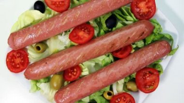 Salata dönen bir görünüm ile beyaz bir arka plan üzerinde plaka üzerinde Wurstels