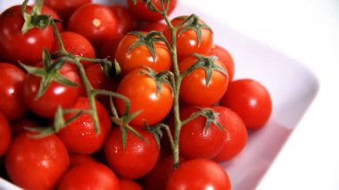 Kiraz domates görülen beyaz bir arka plan üzerinde görünümü döndürme ile yakın