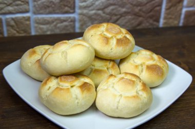 Ahşap bir masa üzerinde bir tabakta ekmek kadar kapatın