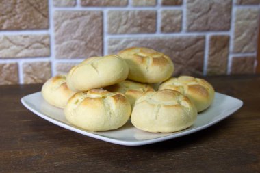 Ahşap bir masa üzerinde bir tabakta ekmek