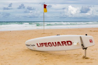 Gold Coast, Avustralya - 5 Ocak 2015: altın kum ile bulutlu bir günde Surfers Paradise plajında sörf tahtası cankurtaran ve Pasifik Okyanusu yukarıda gökyüzü kaplı