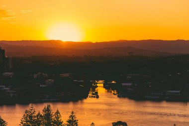 Gold Coast, Avustralya - 17 Ocak 2015: yoğun tropik günbatımı Surfers Paradise dağ manzaralı ve güneş patlaması üzerine