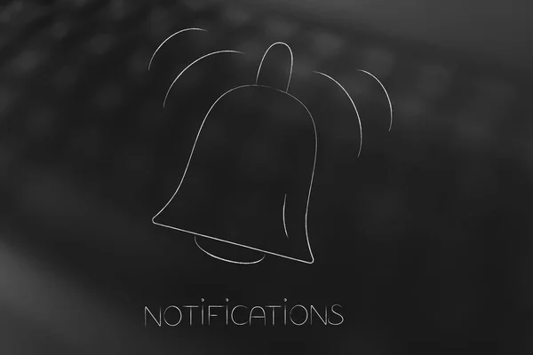 push notifications settings and marketing conceptual illustration: ringing notification bell icon on blurred keyboard background