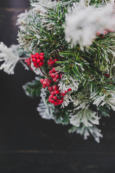 detail of small Christmas tree with snow mistletoe and pine cone decorations, cozy festive winter holidays feeling