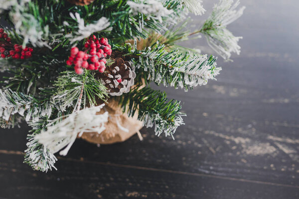 Christmas tree with pine cones and mistletoes berries and hints of snow on the branches, cozy festive winter holidays feeling