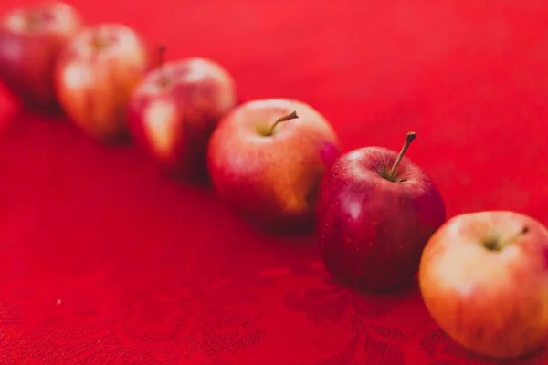 group of red apples on table cloth of the same color shot at shallow depth of field