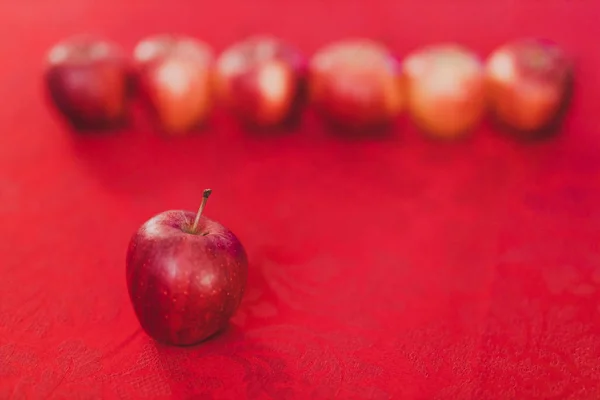 group of red apples on table cloth of the same color shot at shallow depth of field