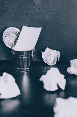 Çöp kutusu Resepsiyon ayarıyla boş not defteri ve buruşuk Kağıt topları, hazırlanması ve belgeler yazmak için mücadele kavramı üzerinde