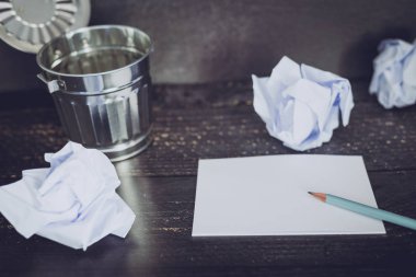 Çöp kutusu Resepsiyon ayarıyla boş not defteri ve buruşuk Kağıt topları, hazırlanması ve belgeler yazmak için mücadele kavramı üzerinde