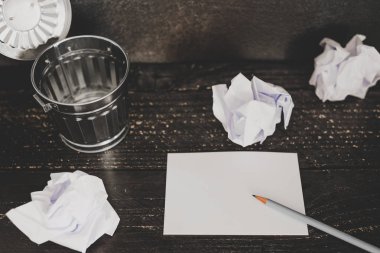 Çöp kutusu Resepsiyon ayarıyla boş not defteri ve buruşuk Kağıt topları, hazırlanması ve belgeler yazmak için mücadele kavramı üzerinde