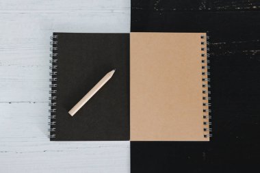 siyah ve beyaz yüzeyüzerinde siyah ve kum kum lu defterler, kontrastlı minimalist düzlük