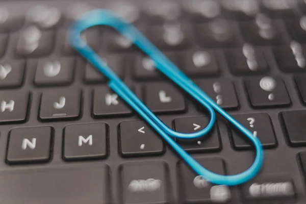 laptop keyboard with clip symbol of email attachments, close-up shot at shallow depth of field