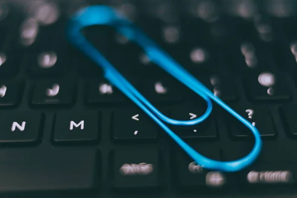 laptop keyboard with clip symbol of email attachments, close-up shot at shallow depth of field