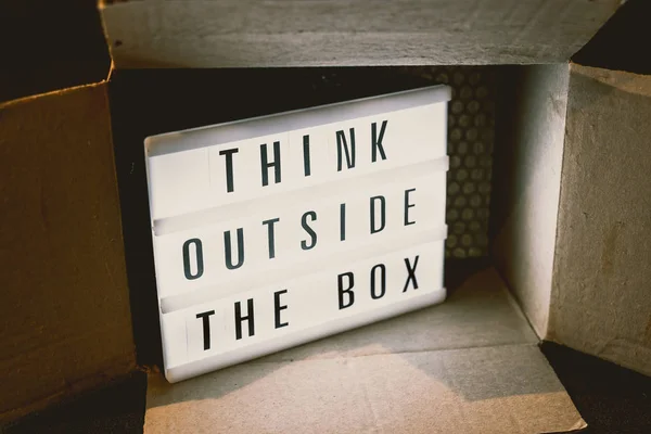 Think outside the box message on lightbox with parcel, concept of being unique for success