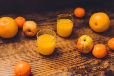 ahşap masa ve suyu gözlük, vitaminler ve iyi beslenme kavramı ile sağlıklı meyve portakal greyfurt ve elma gibi dağınık