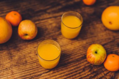 ahşap masa ve suyu gözlük, vitaminler ve iyi beslenme kavramı ile sağlıklı meyve portakal greyfurt ve elma gibi dağınık